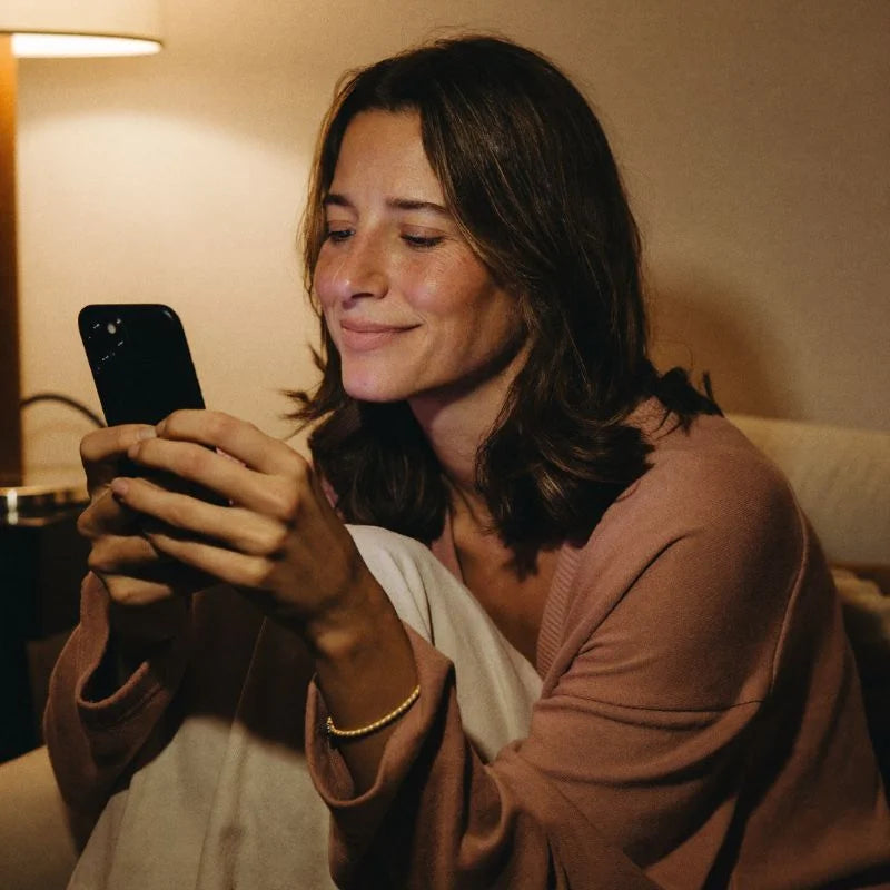 A woman in a cozy evening corner sharing her birth date on her phone